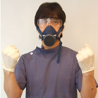 アマルガムを除去する院長の中垣も、手袋、保護メガネ、そして毒ガスマスクをして治療を行っています